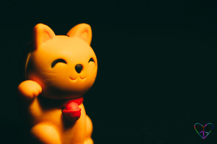 A moody shaded macro shot of a lucky cat figurine